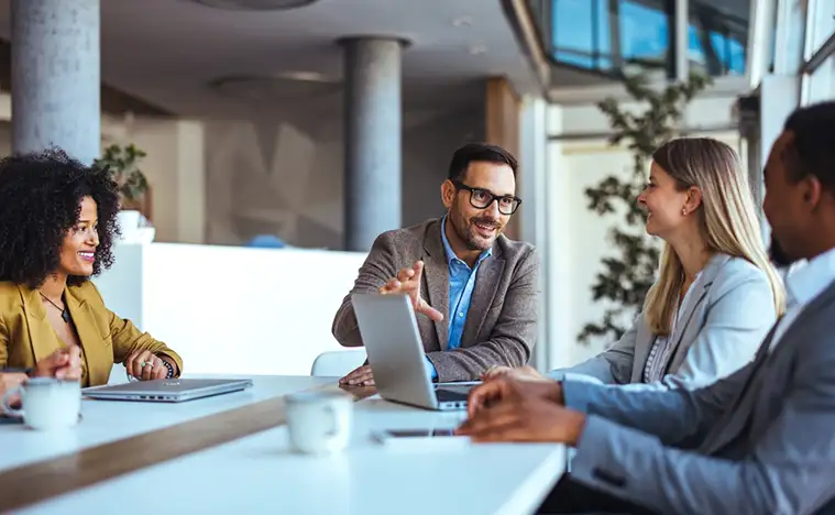 The image showcases professionals engaged in a collaborative meeting, highlighting teamwork, communication, and a productive office environment, captured within a contemporary workspace.